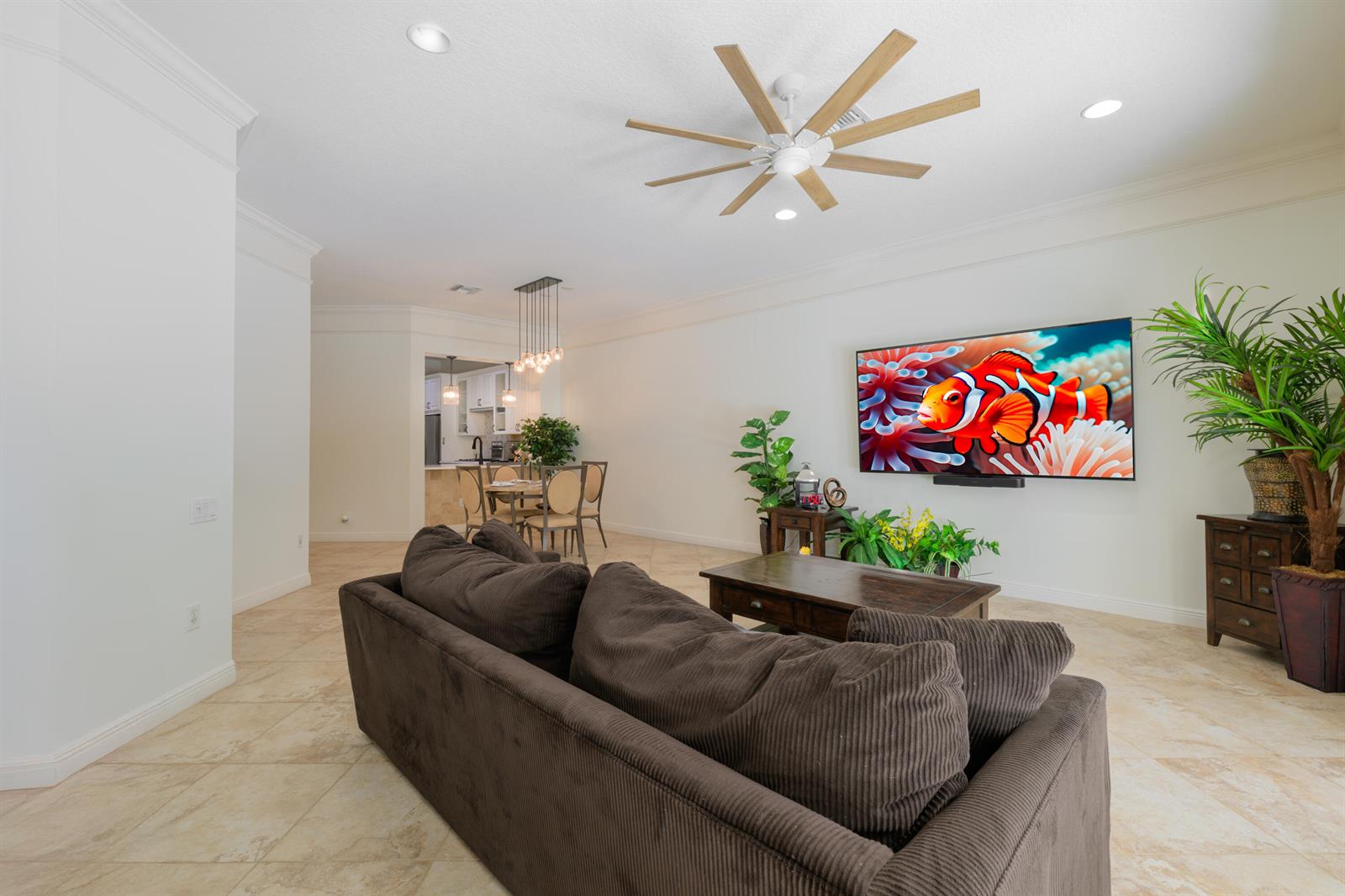 A living room features a brown sofa, a television, a ceiling fan, and tile flooring — 742 Cable Beach Lane, West Palm Beach FL 33410, WEST PALM BEACH, FL
