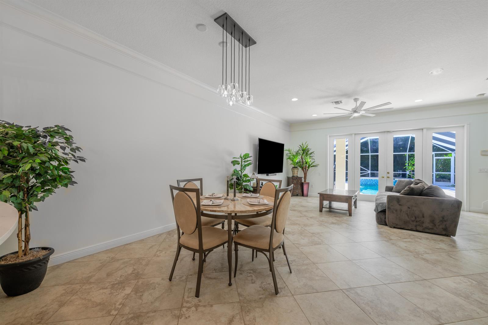 A dining area with a round table and pendant light opens to a living room — 742 Cable Beach Lane, West Palm Beach FL 33410, WEST PALM BEACH, FL