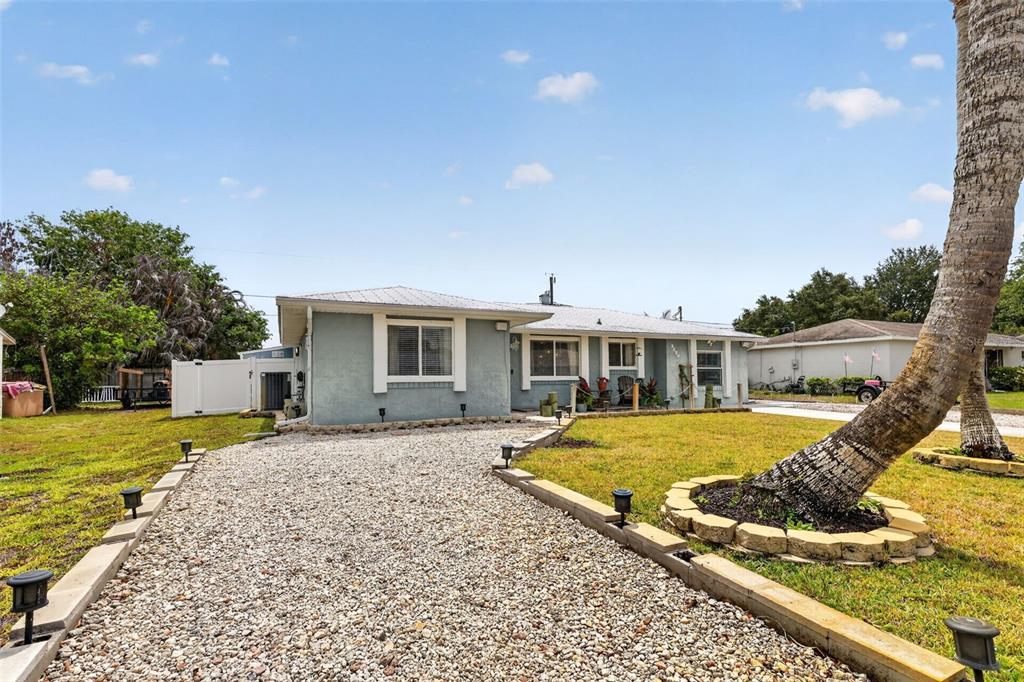 A single-story house with a gravel driveway and a palm tree in the front yard — 2026 7TH COURT SW, VERO BEACH, FL