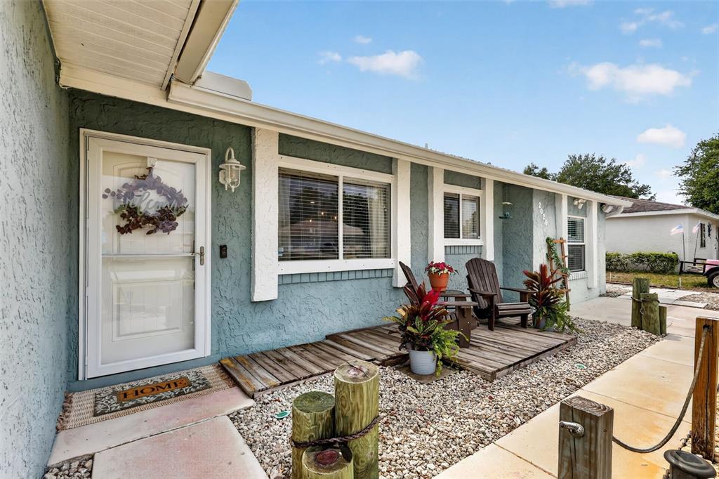 The exterior of a blue house features a wooden deck, gravel landscaping, and nautical-style posts — 2026 7TH COURT SW, VERO BEACH, FL