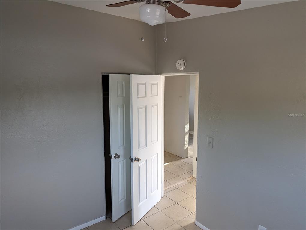 A room with gray walls, a ceiling fan, a closet, and an open doorway — 2000 QUEENSBORO AVENUE S UNIT A, ST PETERSBURG, FL