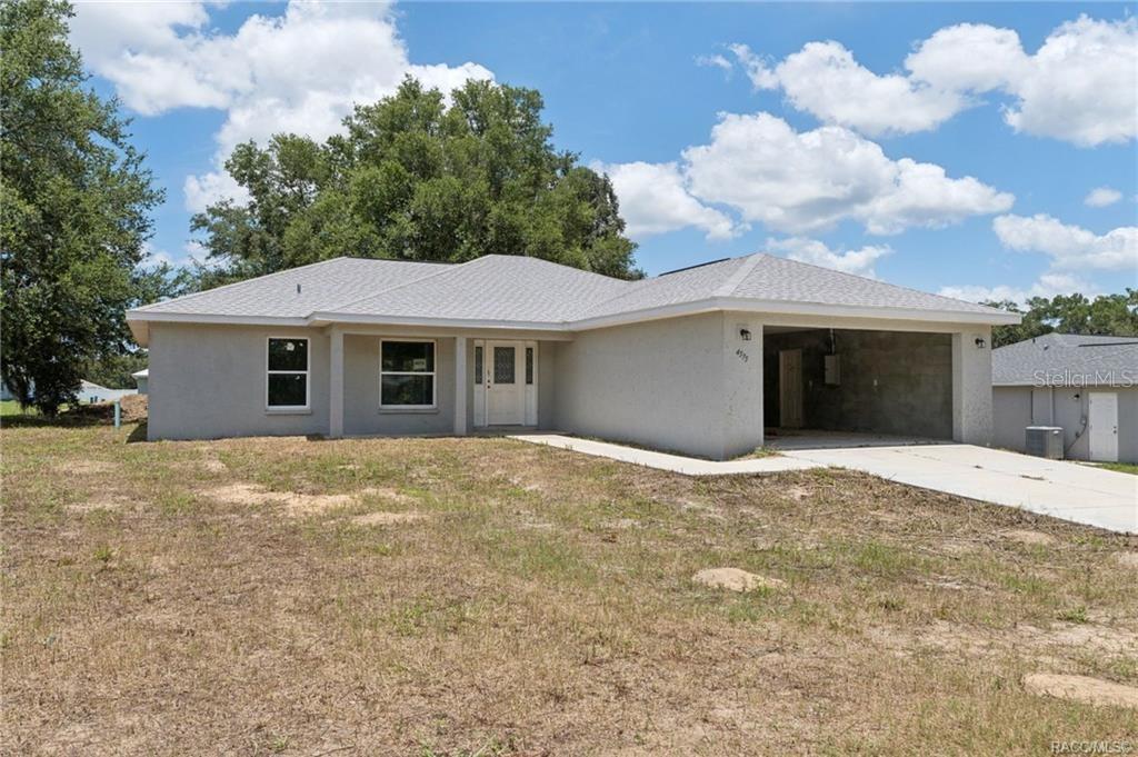 A single-story house with a light-colored stucco exterior and an attached two-car garage — 4575 E WALKER STREET, INVERNESS, FL