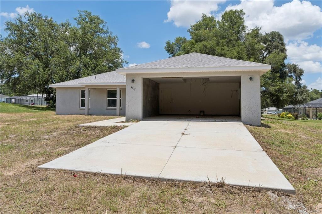 A single-story house with a concrete driveway and an open-front garage under a hip roof — 4575 E WALKER STREET, INVERNESS, FL