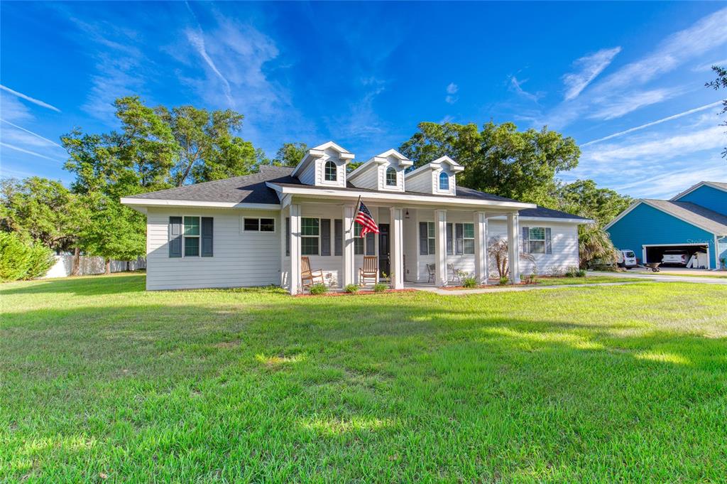 A white single-story house with a front porch, three dormers, and a large grassy lawn — 15 MAPLE STREET, FLAGLER BEACH, FL