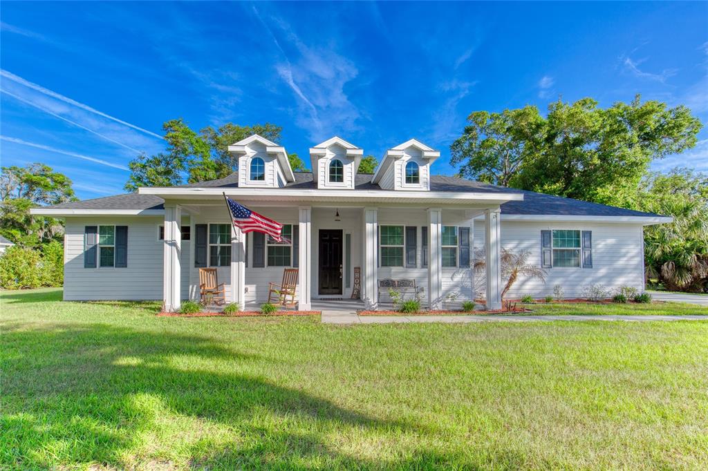 A single-story white house with a front porch, three dormers, and a large lawn — 15 MAPLE STREET, FLAGLER BEACH, FL