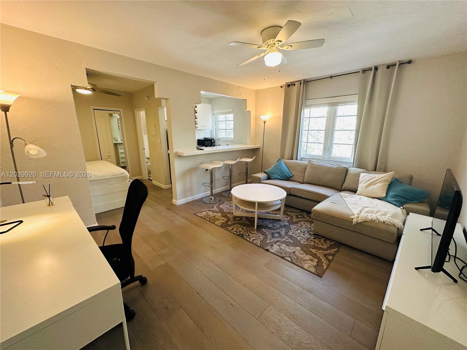 A living room with a sectional sofa, breakfast bar, and an adjacent bedroom area — 260 Euclid Ave # 27, Miami Beach FL 33139, MIAMI BEACH, FL
