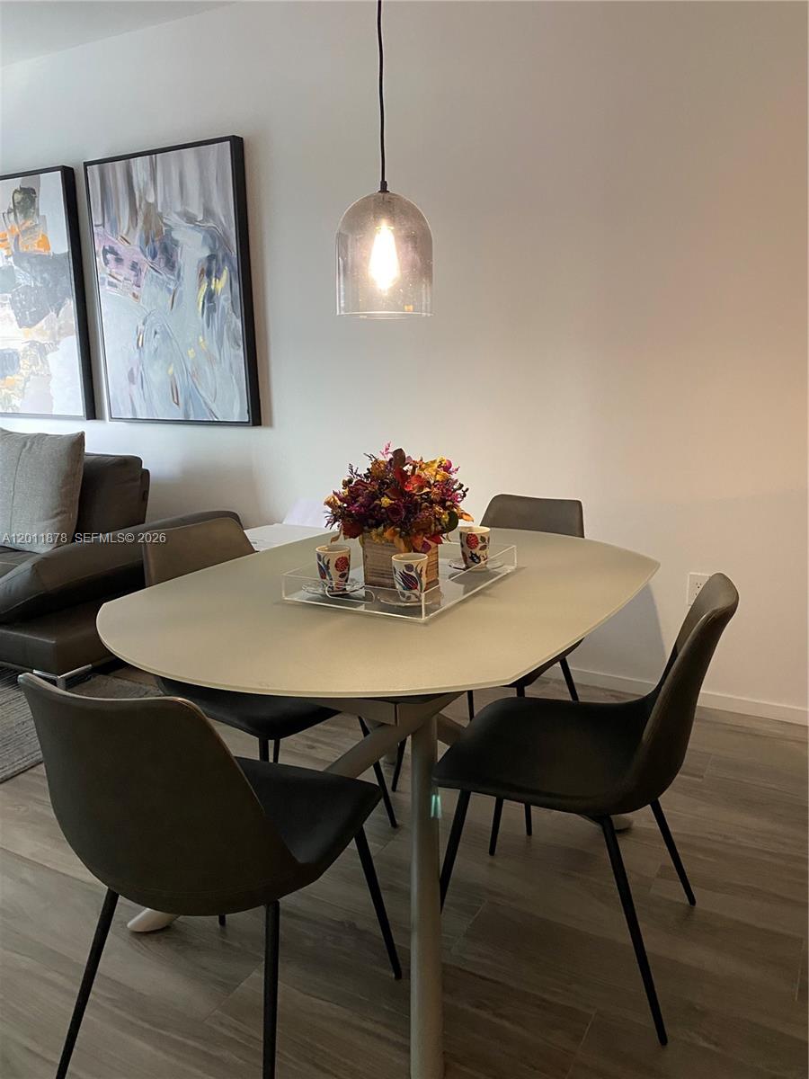 A dining area features a light-colored oval table, four dark chairs, and a pendant light — 801 S Miami Ave # 2306, Miami FL 33130, MIAMI, FL