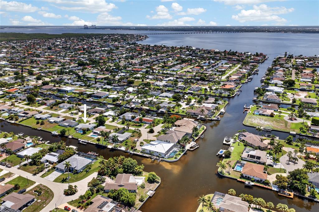 An aerial view shows a residential neighborhood with houses situated along interconnected canals — 3114 SE 18TH AVENUE, CAPE CORAL, FL