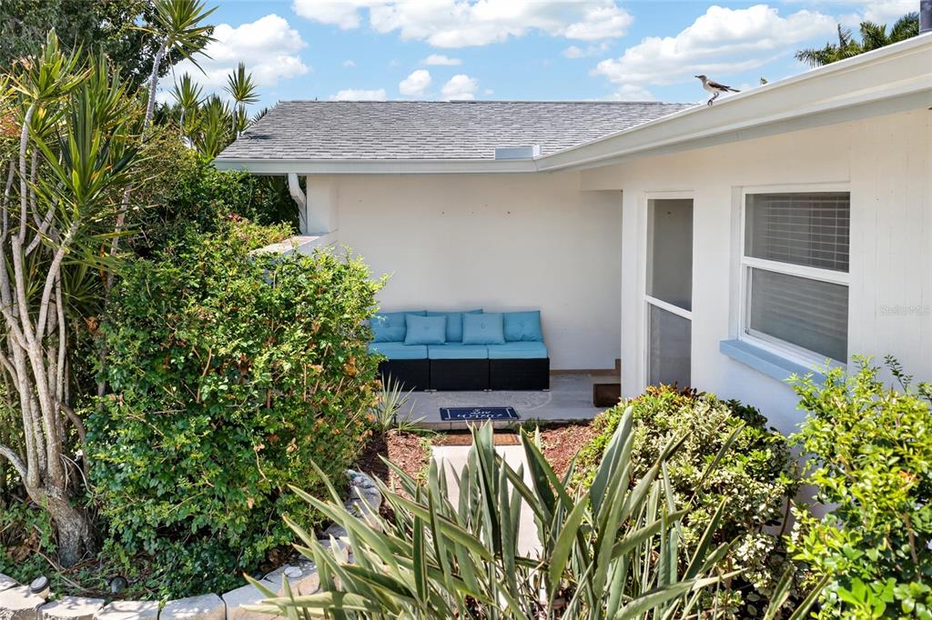A patio area features a blue cushioned sofa set against a white exterior wall — 3114 SE 18TH AVENUE, CAPE CORAL, FL