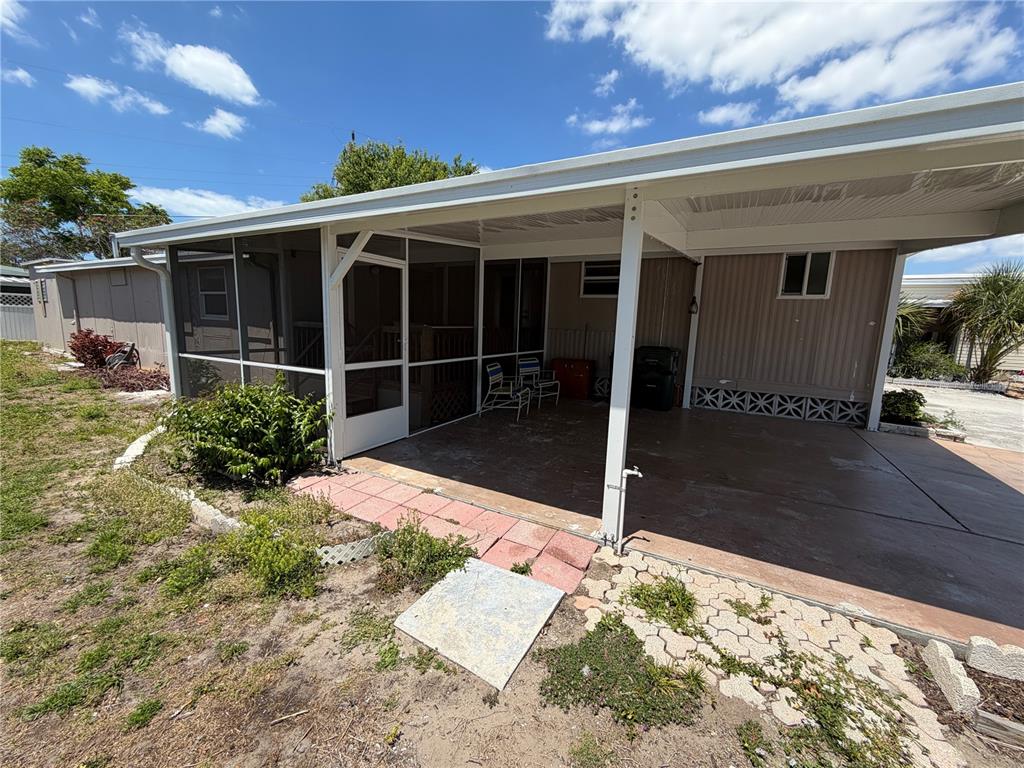 A covered patio area features a screened-in section, concrete flooring, and a metal roof — 4819 SEA ISLAND AVENUE, SARASOTA, FL