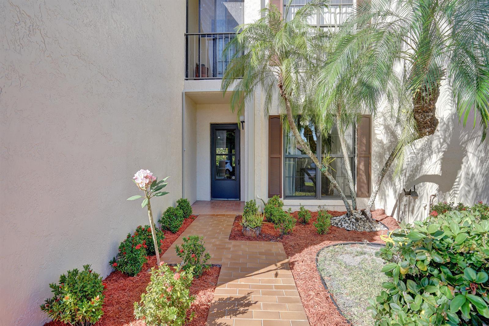 A tiled walkway leads to the front entrance of a two-story home with landscaping — 3068 Lucerne Park Drive, FL 33467, FL