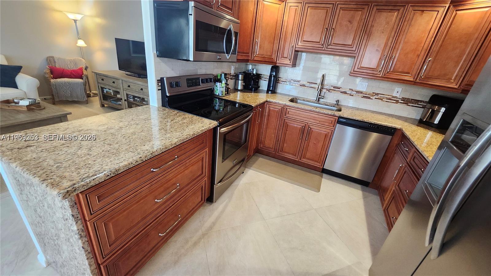 A kitchen features wood cabinets, granite countertops, and stainless steel appliances — 4072 Ventnor P # 4072, Deerfield Beach FL 33442, DEERFIELD BEACH, FL