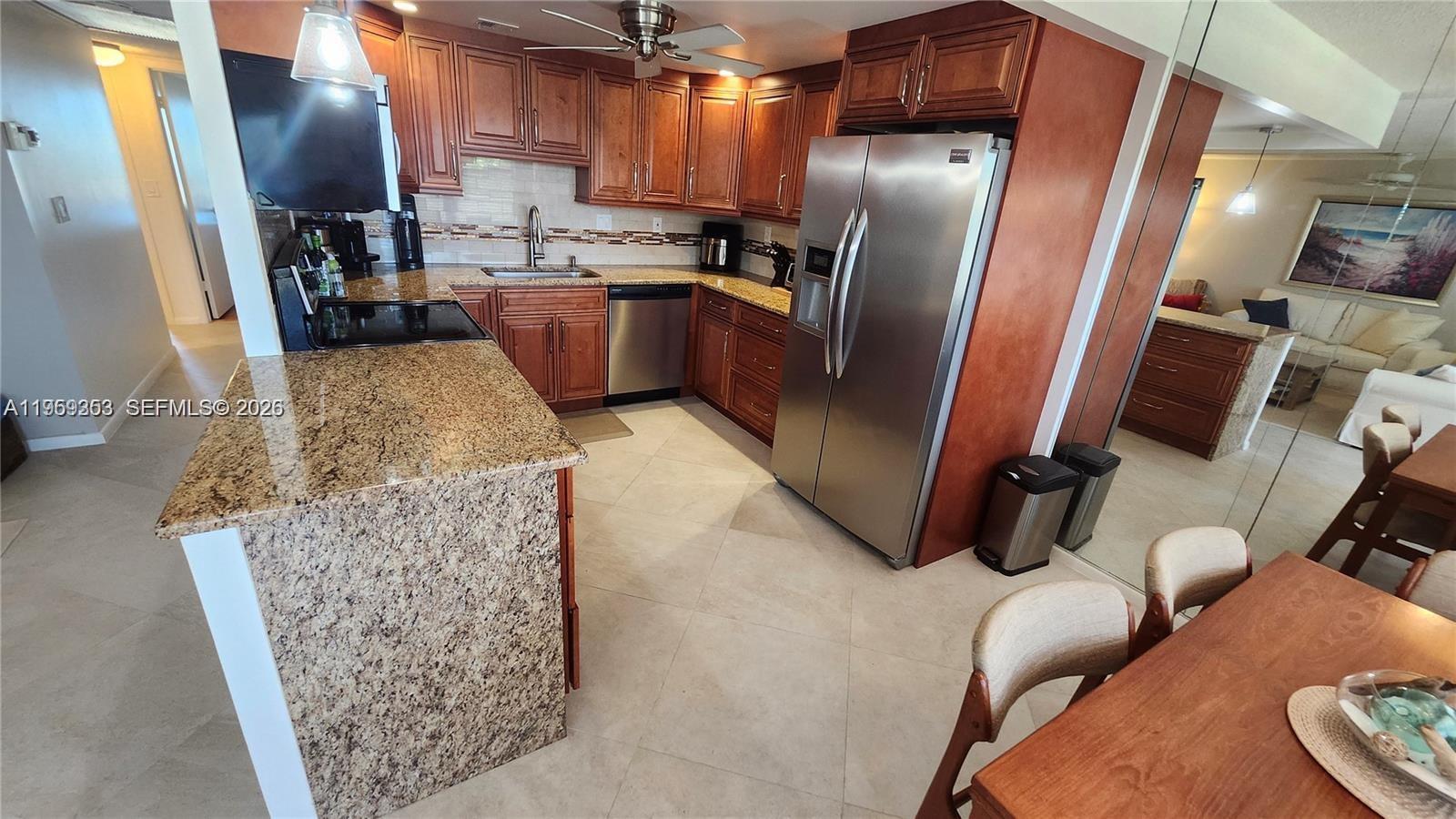 A kitchen features wood cabinets, granite countertops, stainless steel appliances, and tile flooring — 4072 Ventnor P # 4072, Deerfield Beach FL 33442, DEERFIELD BEACH, FL