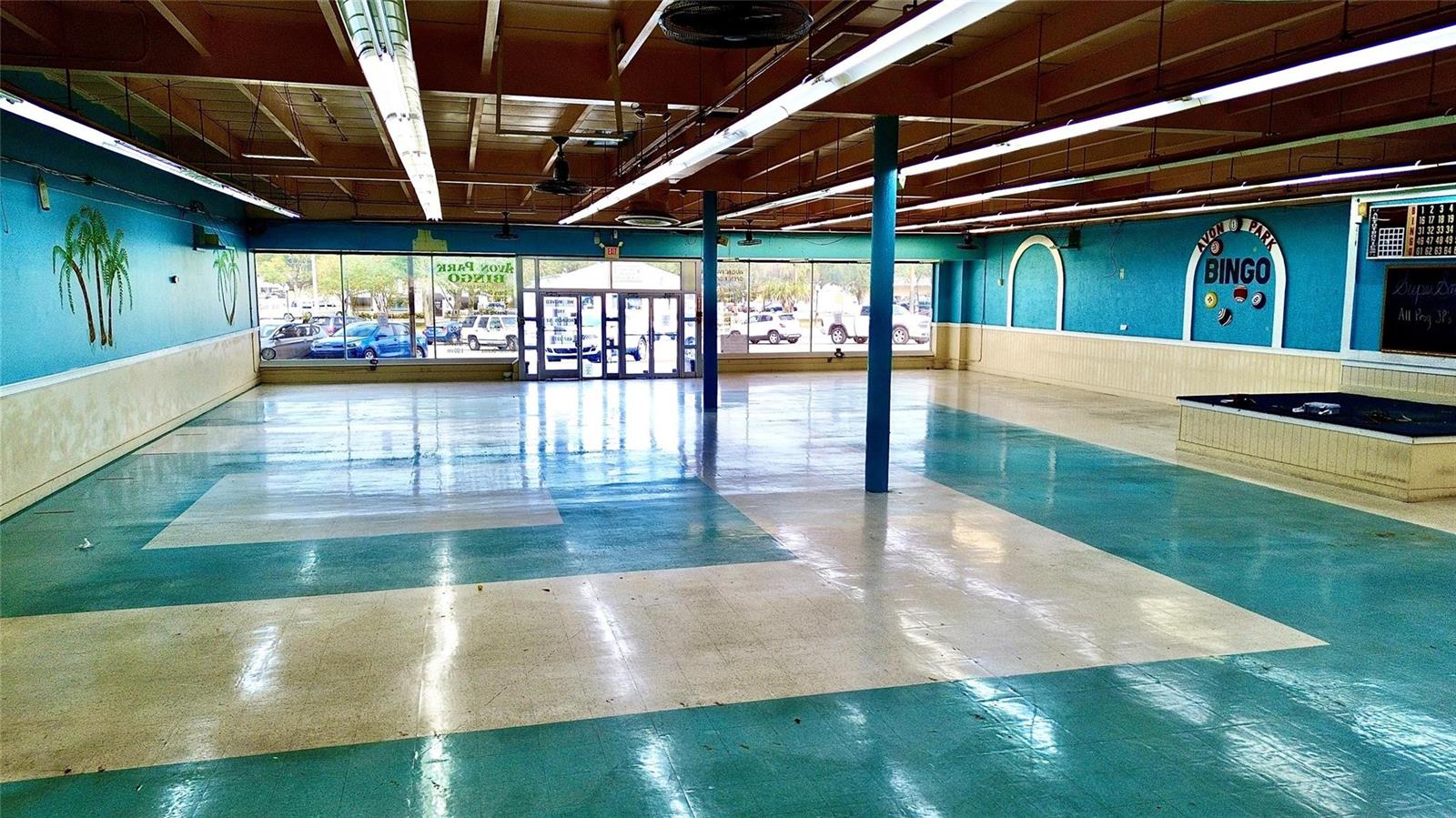 An empty bingo hall features teal and white tiled floors, blue walls, and fluorescent lighting — 1091 W Main Street, FL 33825, FL