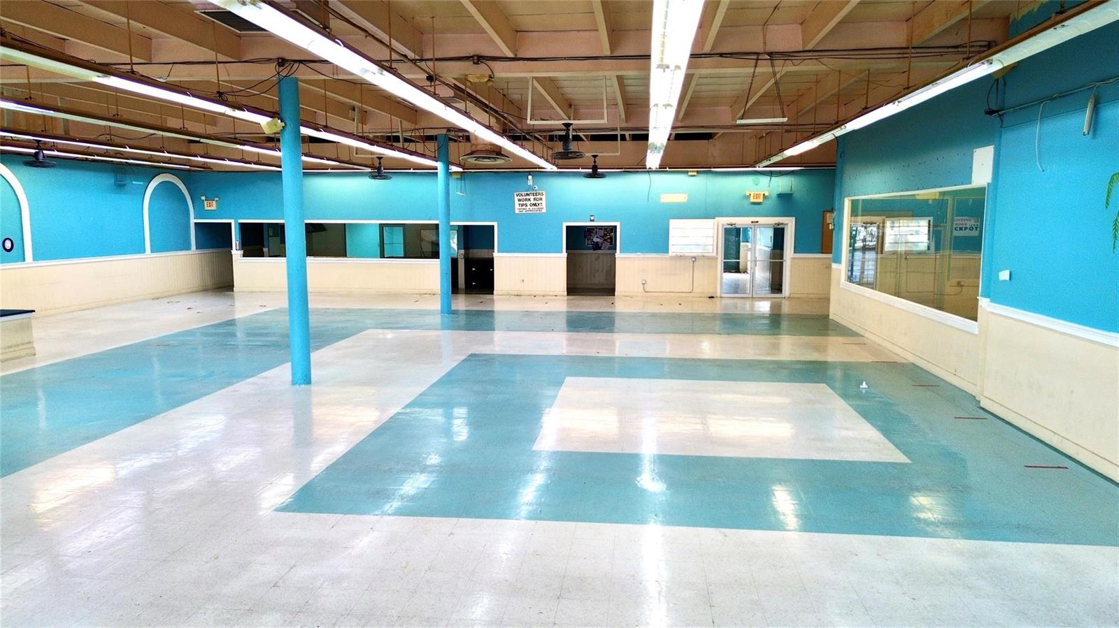 A large, vacant commercial room features blue walls, white wainscoting, and a patterned tile floor — 1091 W Main Street, FL 33825, FL