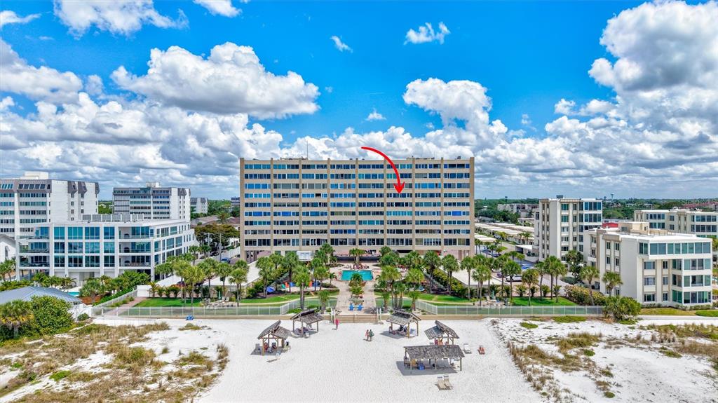An aerial view of a multi-story beachfront condominium building with a pool and sandy beach — 6140 MIDNIGHT PASS ROAD UNIT 603, SARASOTA, FL