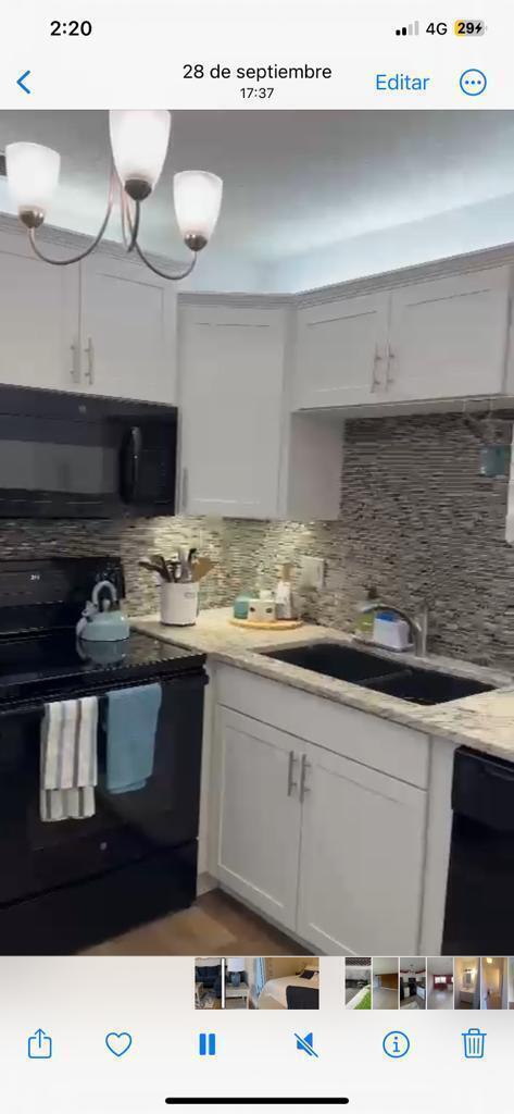 A kitchen features white cabinets, a black stove, a dark sink, and a textured backsplash — 86 Crooked Tree Lane # 102, Vero Beach FL 32962, VERO BEACH, FL