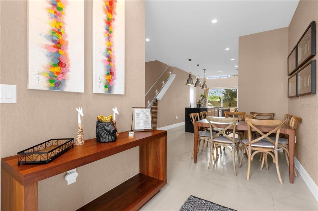 A wooden console table sits in a foyer leading to a dining area and kitchen — 3215 BRASILIA AVENUE, KISSIMMEE, FL