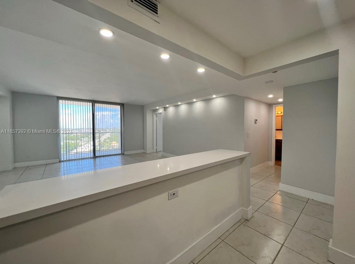 A bright, open-concept living area features white tile flooring, recessed lighting, and a breakfast bar — 13499 Biscayne Blvd # 1405, North Miami FL 33181, NORTH MIAMI, FL