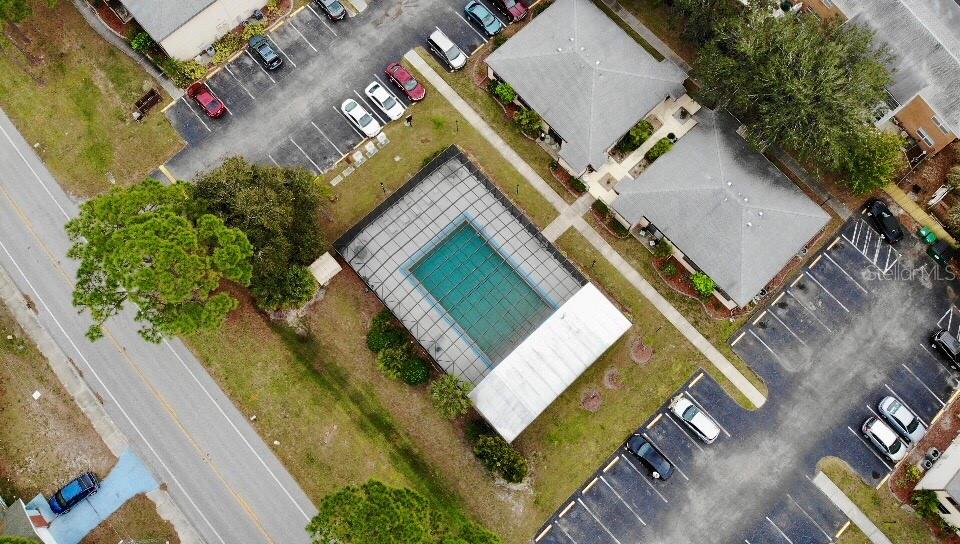 An aerial view shows a screened-in swimming pool surrounded by parking lots and residential buildings — 22291 WESTCHESTER BOULEVARD UNIT 206, PORT CHARLOTTE, FL