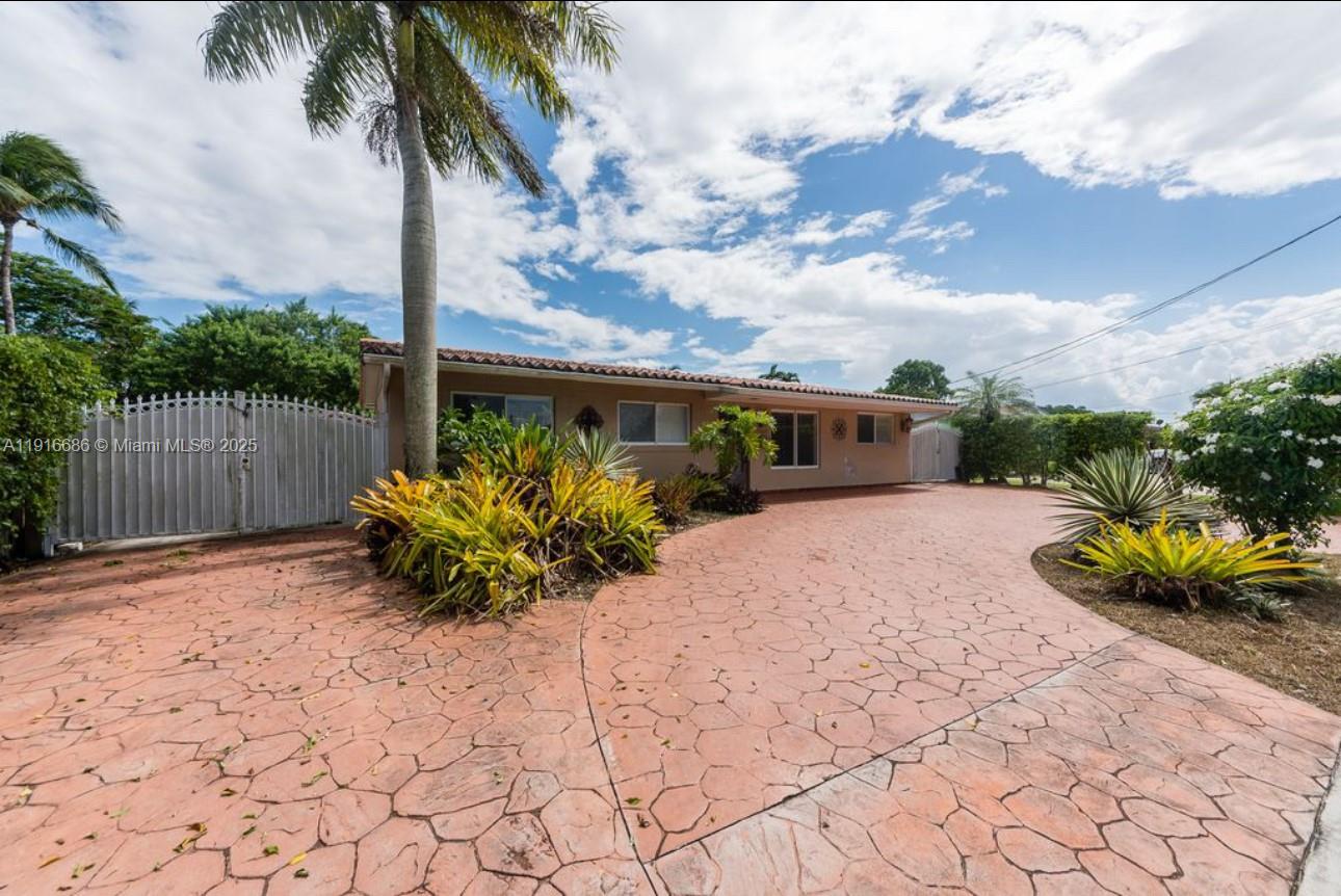 A single-story house with a stamped concrete driveway and tropical landscaping under a blue sky — 10260 SW 48th St, Miami FL 33165, MIAMI, FL