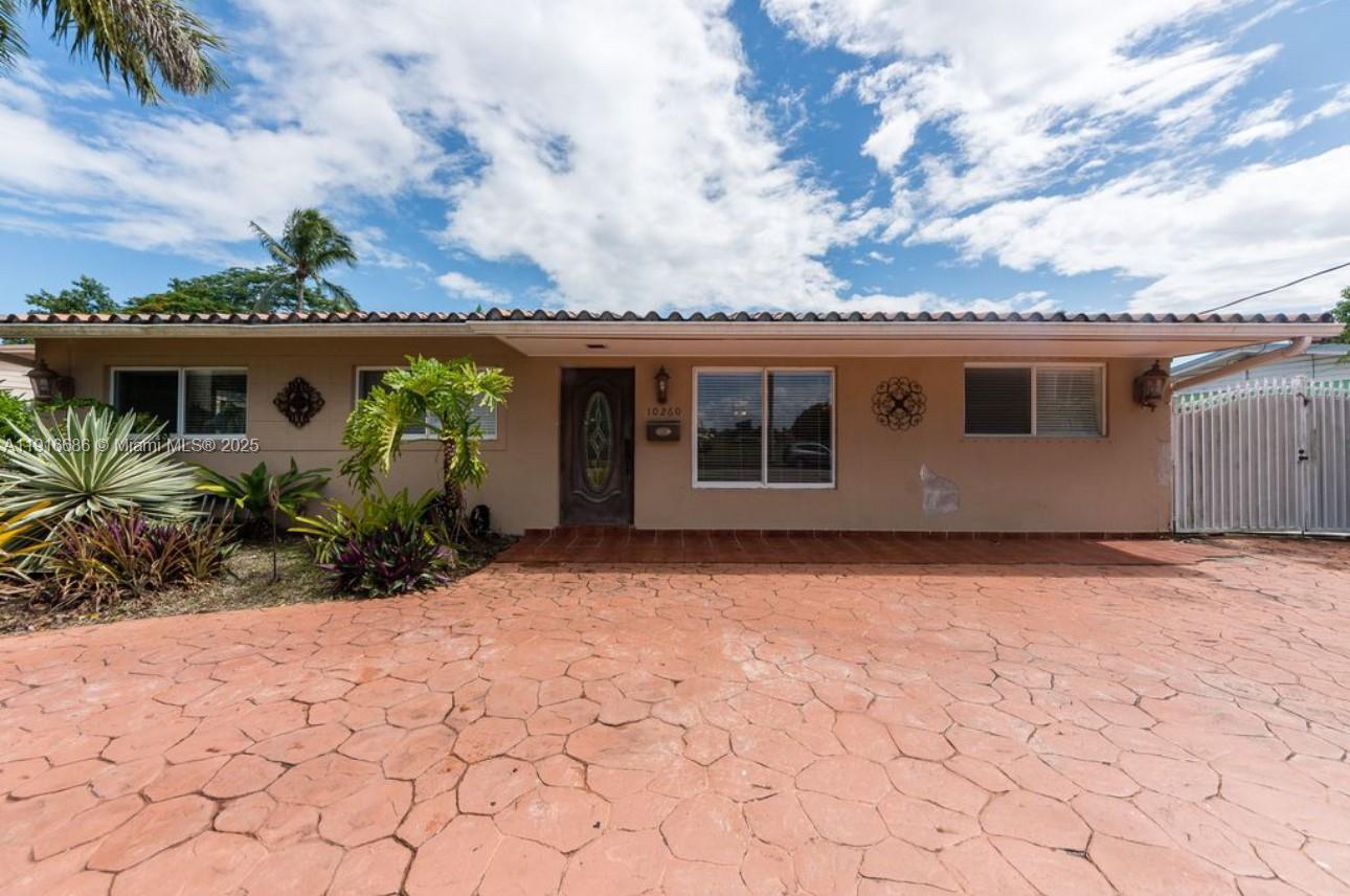 A single-story house with a tan exterior, a tiled driveway, and a front entrance — 10260 SW 48th St, Miami FL 33165, MIAMI, FL