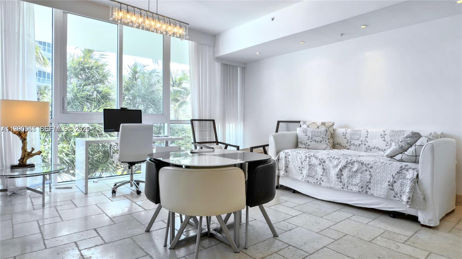 A bright living area features a dining set, a desk, and a sofa on tile floors — 50 S Pointe Dr # 504, Miami Beach FL 33139, MIAMI BEACH, FL
