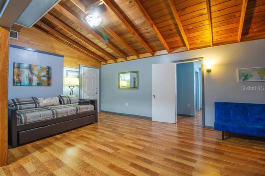 A room with wood-plank ceilings, hardwood floors, a daybed, and a blue sofa — 1731 GRAYSON DRIVE, ORLANDO, FL