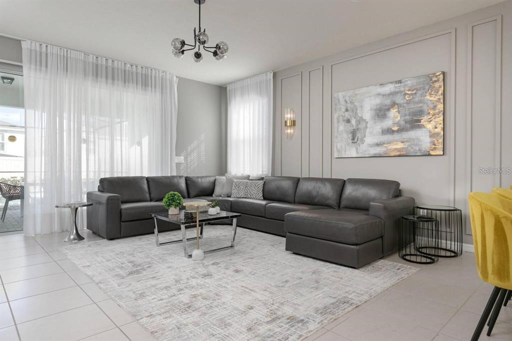 A living room features a large gray sectional sofa, a coffee table, and wall molding — 1671 KONA LANE, DAVENPORT, FL