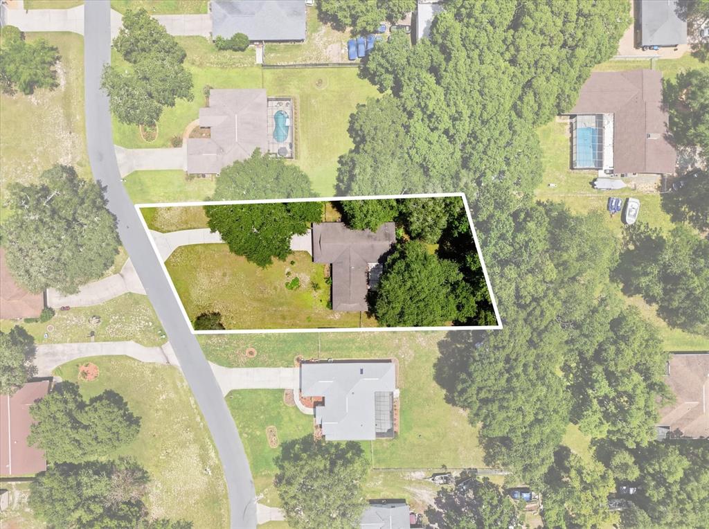 An aerial view shows a house with a large yard and trees on a lot — 3103 S BAY BERRY POINT, INVERNESS, FL