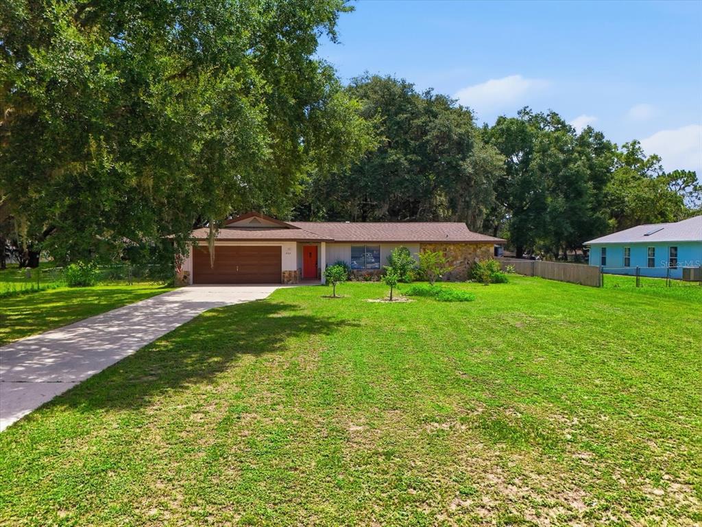 A single-story house with a brown garage door and a large front lawn — 3103 S BAY BERRY POINT, INVERNESS, FL