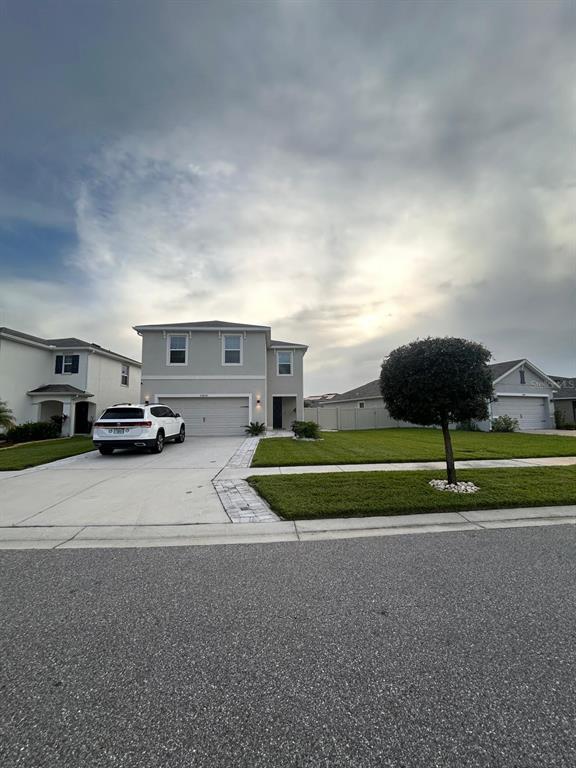 A two-story suburban house with a concrete driveway, a white SUV, and a manicured lawn — 32804 BROOKS HAWK LN, WESLEY CHAPEL, FL