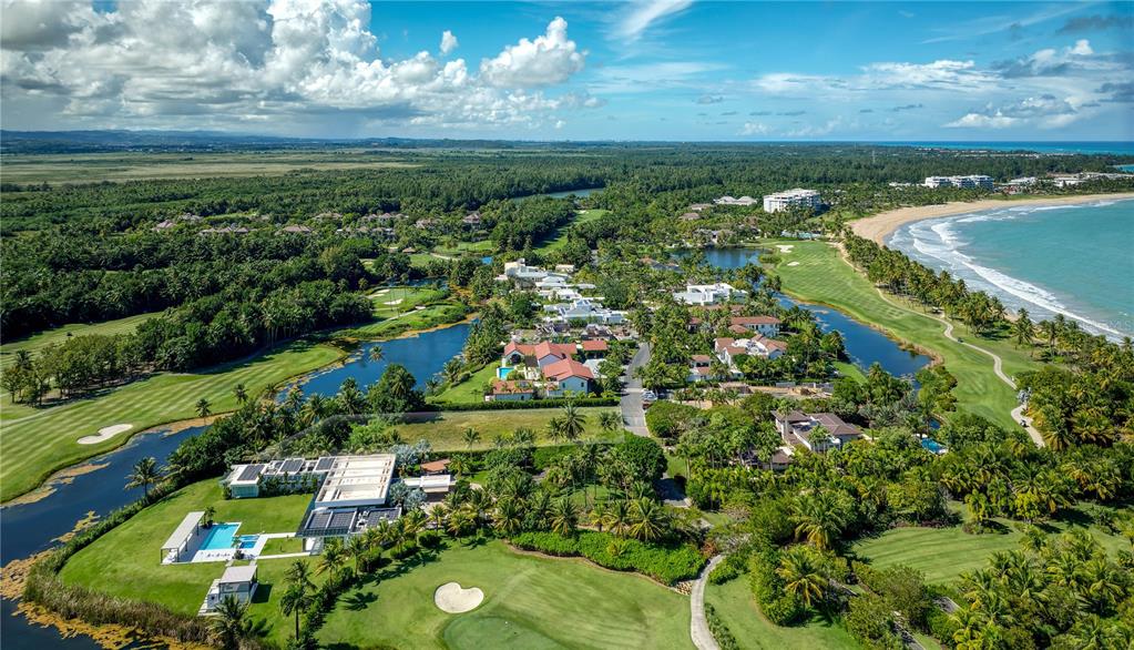 An aerial view shows a coastal residential community with houses, swimming pools, and golf courses — 7000 BAHIA BEACH BOULEVARD UNIT 19 Las Estancias, RIO GRANDE, PR