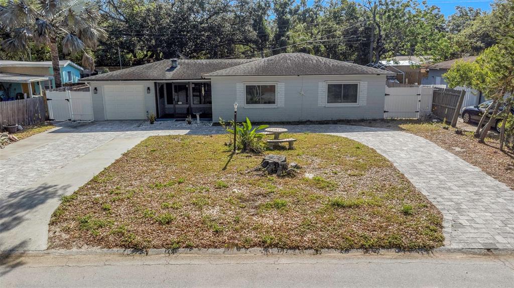 A single-story house with a paved driveway and a front yard featuring a tree stump — 2025 TEMPLE TERRACE, CLEARWATER, FL