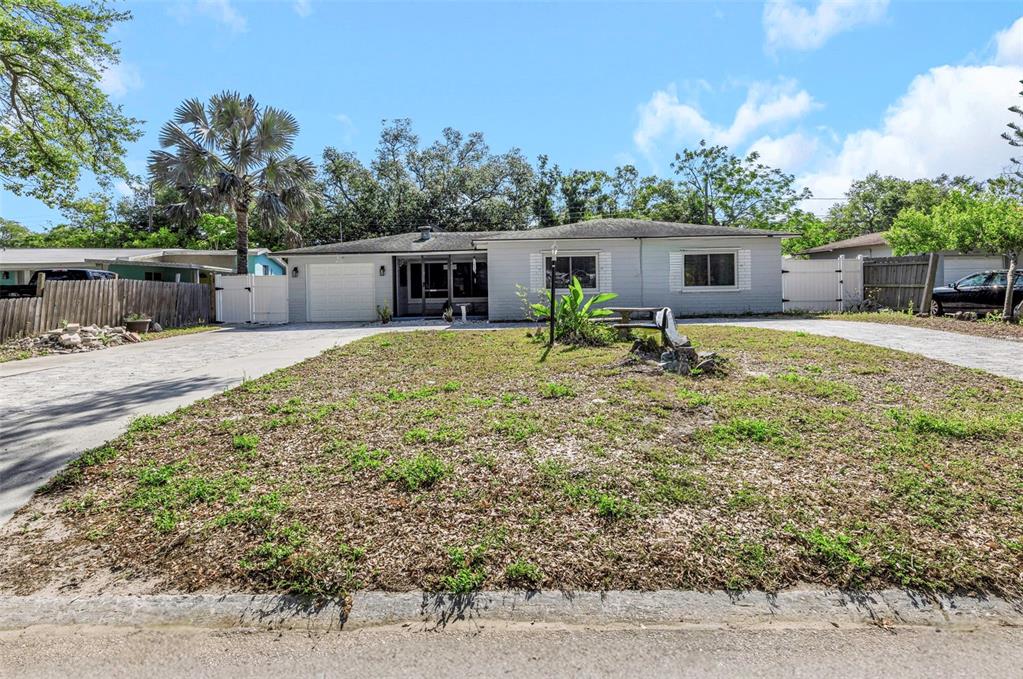 A single-story house with a light gray exterior, a front garage, and a large yard — 2025 TEMPLE TERRACE, CLEARWATER, FL