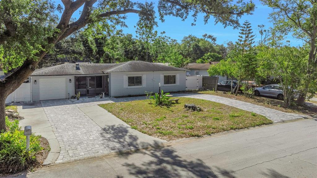 A single-story house with a paved driveway, a front lawn, and a large oak tree — 2025 TEMPLE TERRACE, CLEARWATER, FL