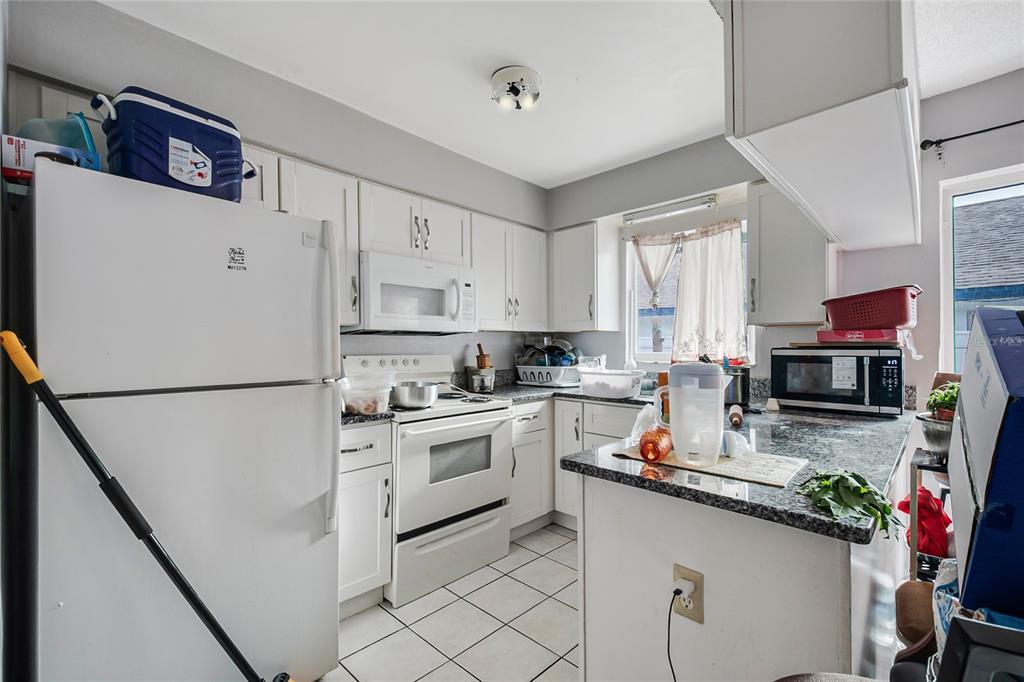A kitchen with white cabinets, white appliances, and granite countertops — 4721 WATCH HILL COURT, ORLANDO, FL