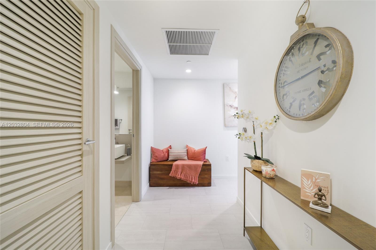 A hallway features a wooden bench, a wall-mounted console table, and a large decorative clock — 1000 Brickell Plz # 4401, Miami FL 33131, MIAMI, FL