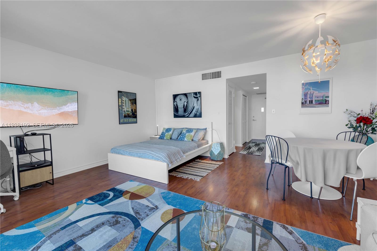 A studio apartment features a bed, dining area, and living space with wood-look flooring — 1200 West Ave # 811, Miami Beach FL 33139, MIAMI BEACH, FL