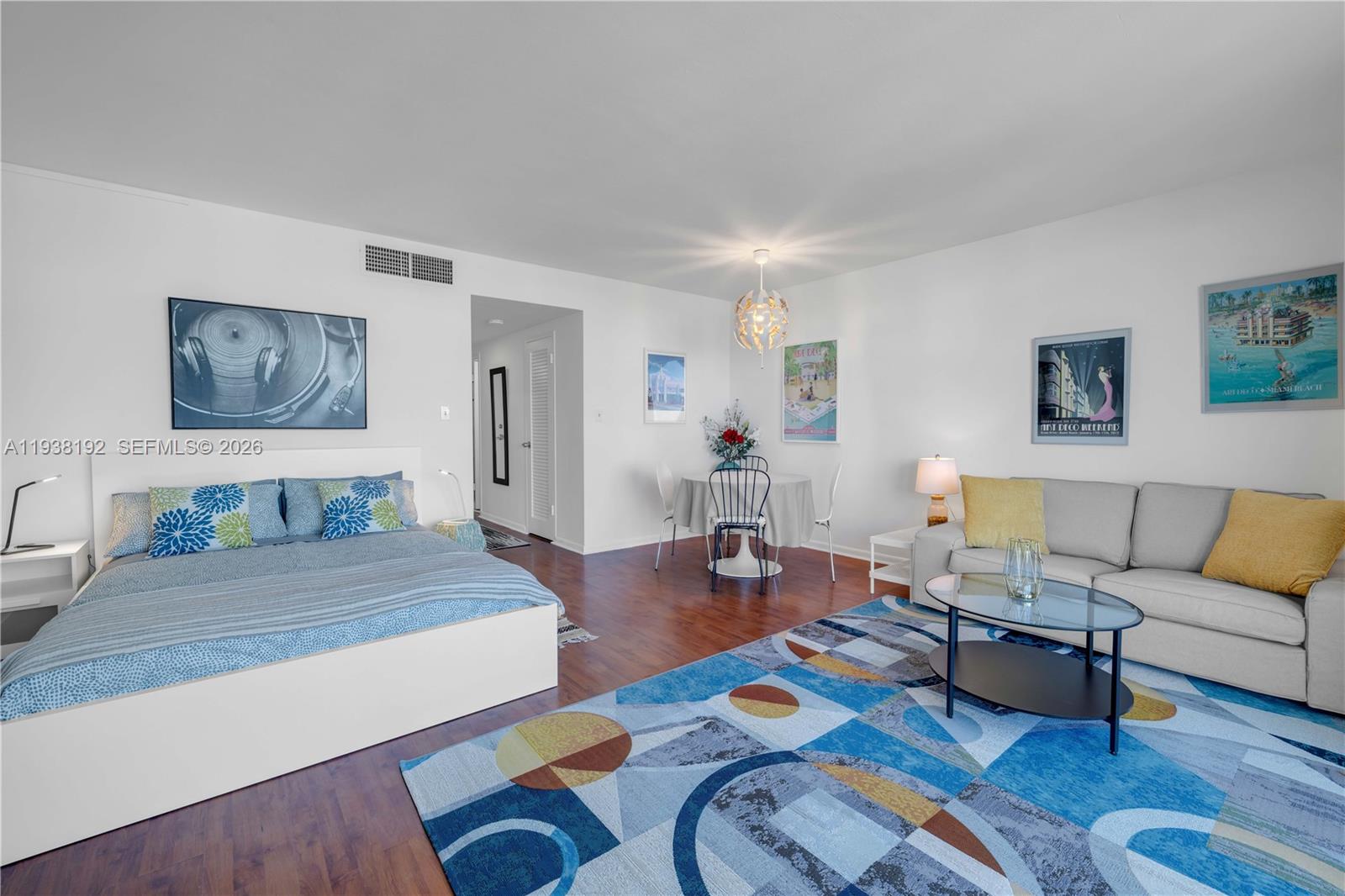 A studio apartment features a bed, a dining area, and a sofa on a patterned rug — 1200 West Ave # 811, Miami Beach FL 33139, MIAMI BEACH, FL