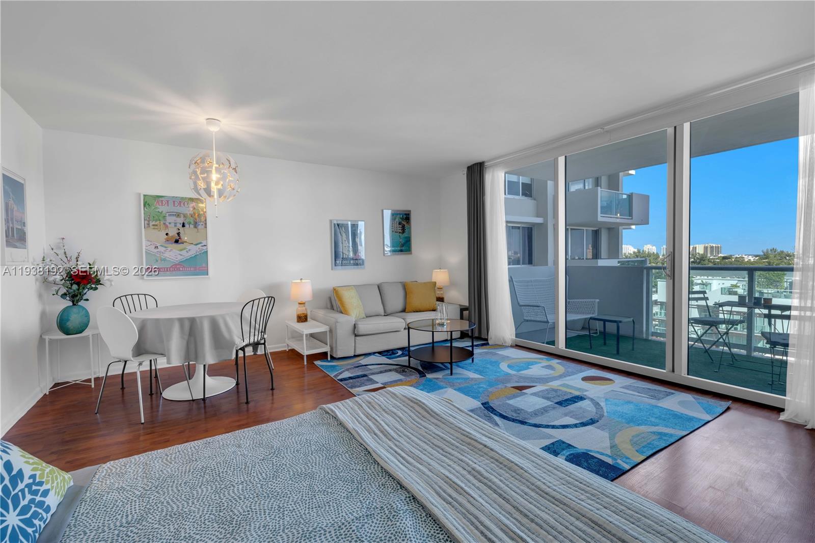 A studio apartment features a bed, dining area, sofa, and a balcony with outdoor seating — 1200 West Ave # 811, Miami Beach FL 33139, MIAMI BEACH, FL
