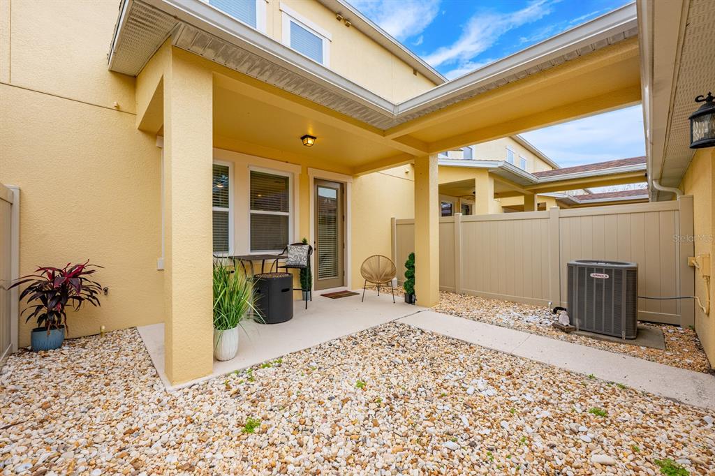 A covered patio with a gravel yard, outdoor furniture, and an air conditioning unit — 12305 VIA DERNA PLACE, WINDERMERE, FL
