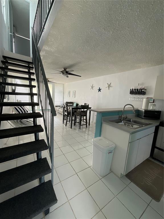 A kitchen and dining area with tile floors, a staircase, and a ceiling fan — Villa Marina Village APT 5 B, FAJARDO, PR