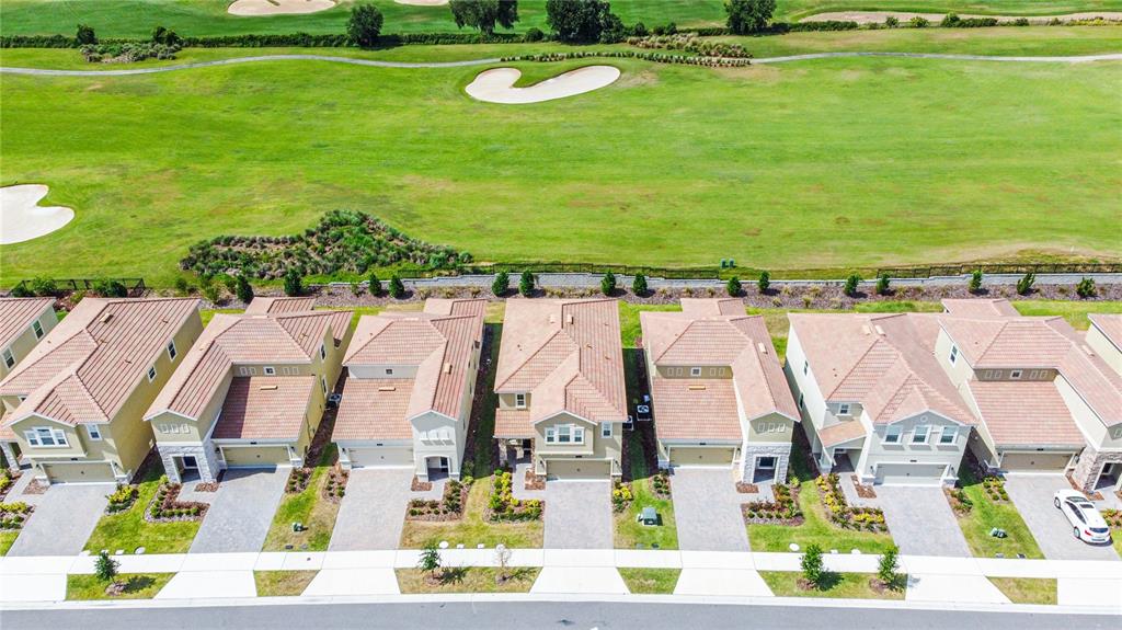 An aerial view shows a row of suburban houses backing onto a golf course — 1043 BLACKWOLF RUN ROAD, DAVENPORT, FL