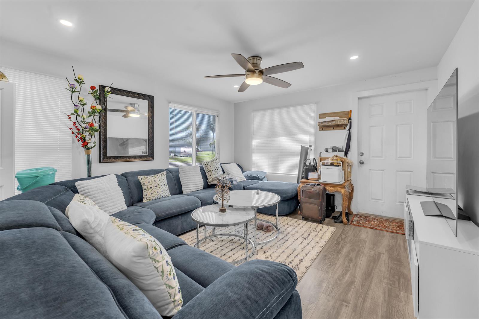 A living room features a large blue sectional sofa, two round coffee tables, and a television — 621 NW 15th Avenue, Pompano Beach FL 33069, POMPANO BEACH, FL