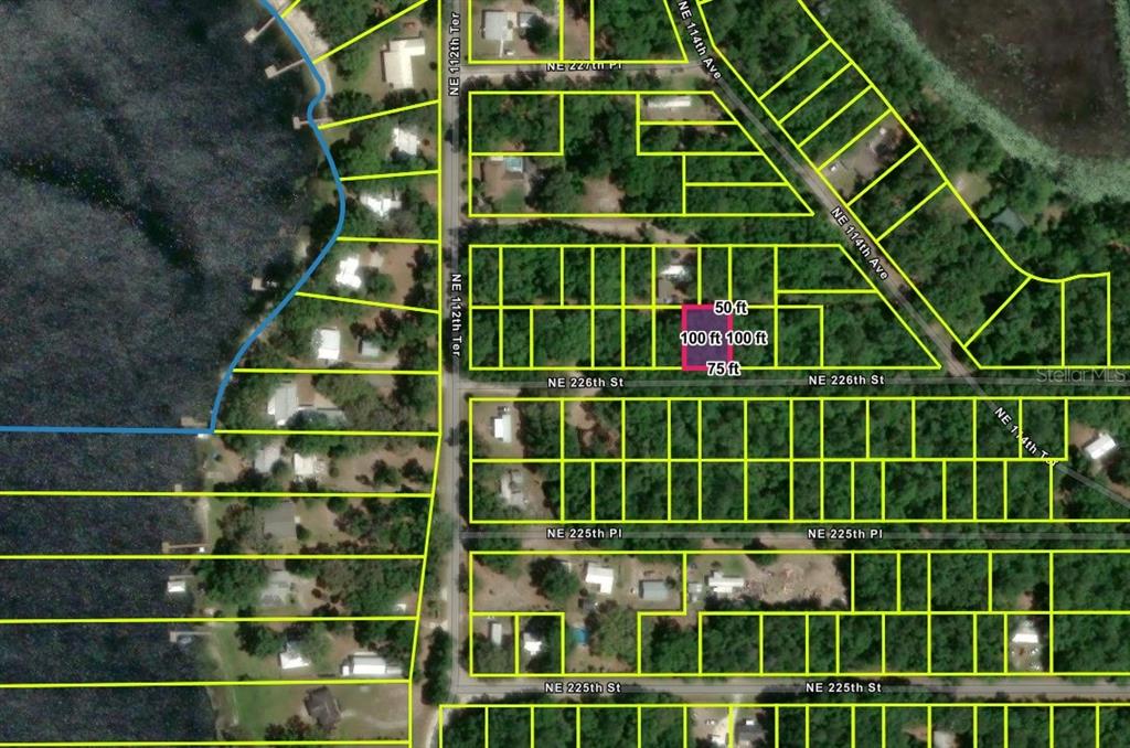 This is an aerial map showing a highlighted rectangular lot among residential properties — NE 112TH TERRACE, FORT MC COY, FL
