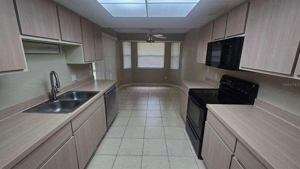 An empty room with light-colored walls, wood-look flooring, and a ceiling fan — 3708 FONTAINEBLEAU STREET, NORTH PORT, FL