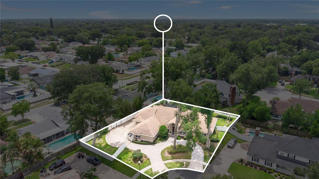 An aerial view shows a single-story house with a tiled roof and a paved driveway — 1889 BERKELEY COURT, MAITLAND, FL