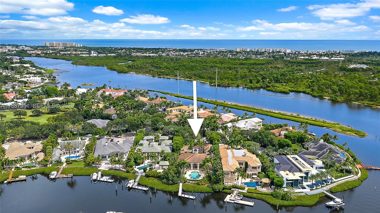 An aerial view shows a waterfront residential property with a swimming pool and private dock — 193 Spyglass Ct, Jupiter FL 33477, JUPITER, FL