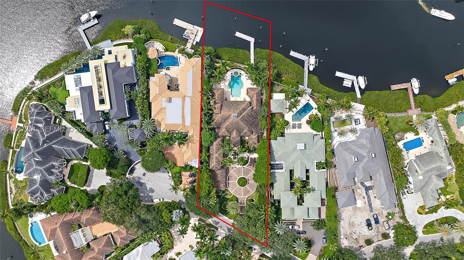 An aerial view shows a waterfront residential property with a large house, pool, and dock — 193 Spyglass Ct, Jupiter FL 33477, JUPITER, FL